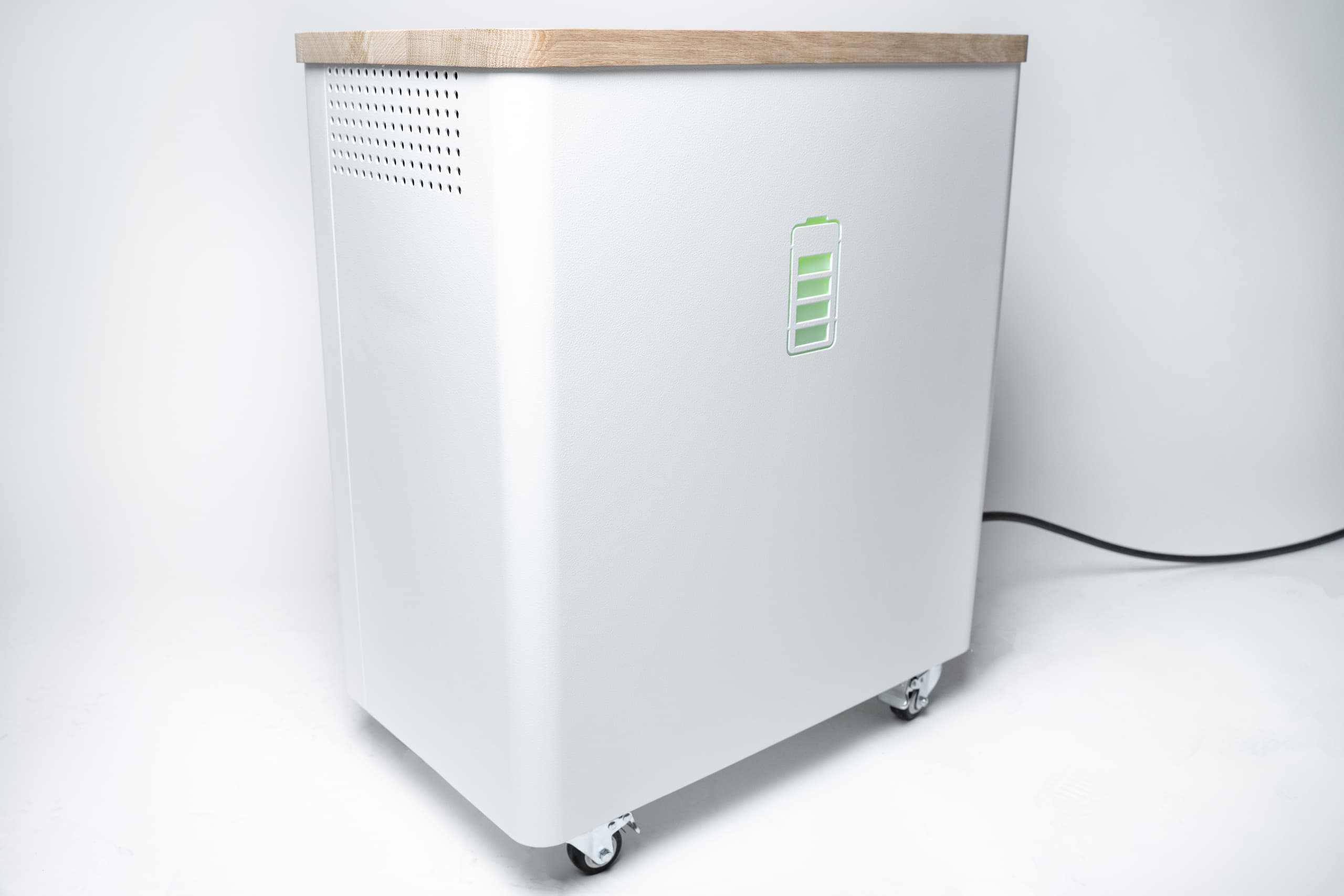 Der YOUL ONE Batteriespeicher in der Frontansicht: Ein eleganter, weißer Stromspeicher mit hochwertigem Holzdeckel, integrierten Transportrollen und einem leuchtenden Batterie-Icon als Ladestandsanzeige.