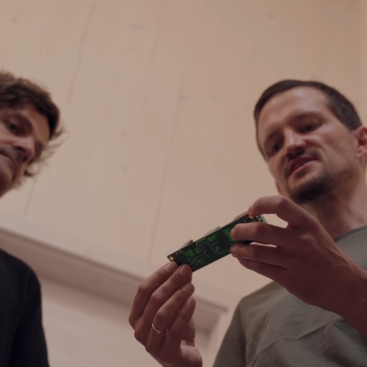 Präzision in der Entwicklung: Norbert Baumann und ein Teamkollege von YOULIQ prüfen sorgfältig eine elektronische Komponente für den YOULIQ one Batteriespeicher.