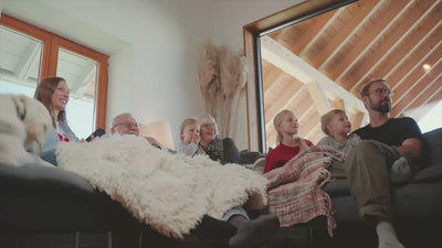 Video zeigt eine Famlie beim Fernsehen im Wohnzimmer, beim Kochen und Essen und beim Staubsaugen, es wird also Strom verbraucht. Im Flur bzw in der offenen Küche steht ein YOULIQ Batteriespeicher, der die Familie mit gespeichertem Strom ihrer PV-Anlage versorgt. 